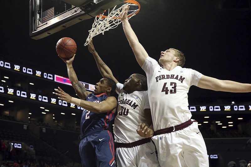 Richmond guard Khwan Fore (2) goes to the basket past Fordham forward Ryan Rhoomes (30) and forward Christian Sengfelder (43) during the first half of an NCAA college basketball game in the Atlantic 10 men's tournament, Thursday, March 10, 2016, in New York. (AP Photo/Mary Altaffer)

