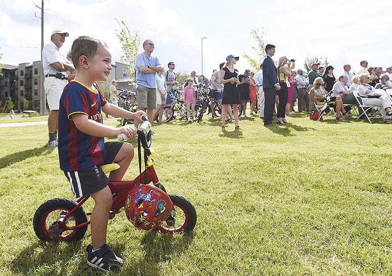 Three-year-old Isaac Sweets watches the grand opening ceremony of the 3-mile extension of the Riverwalk.