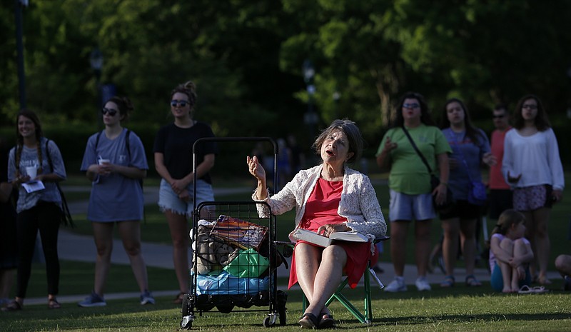 PattyGale Godfrey[cq], center, sings in praise during a National Day of Prayer event at Coolidge Park on Thursday, May 3, 2018 in Chattanooga, Tenn.