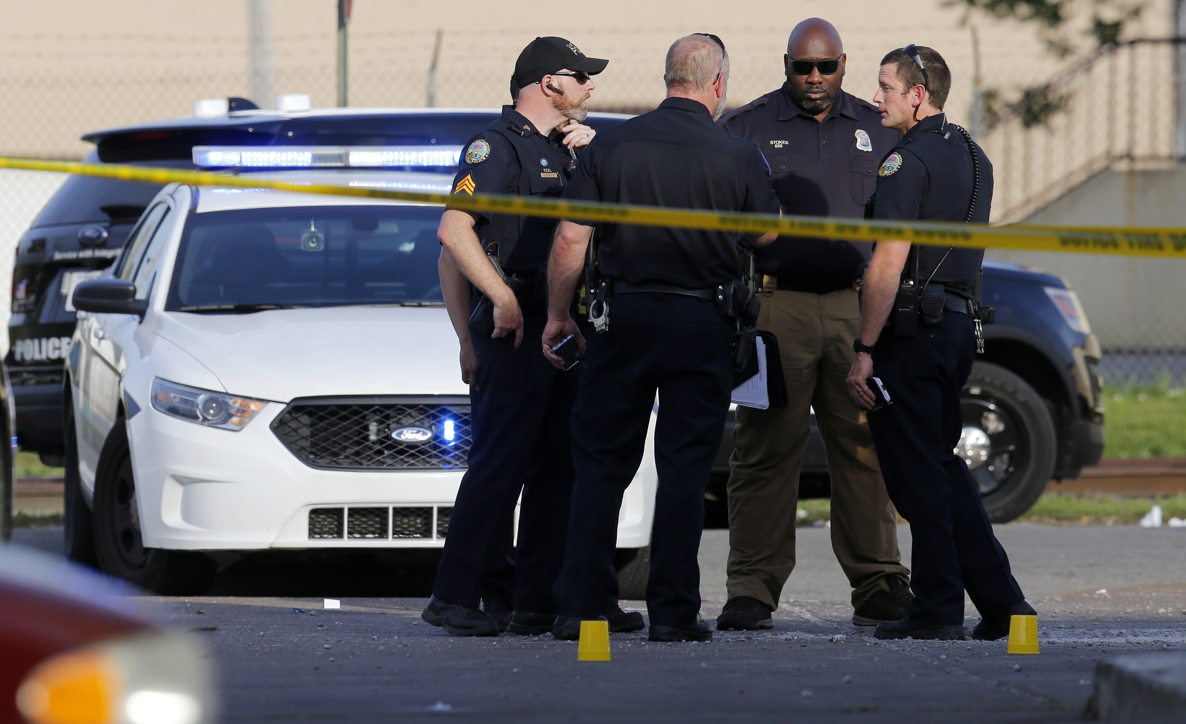 A group of officers talk outside of the Nine Brothers convenience store, where a fatal shooting occurred, at the intersection of Central Avenue and West 38th Street on Sunday, May 6, 2018 in Chattanooga, Tenn.