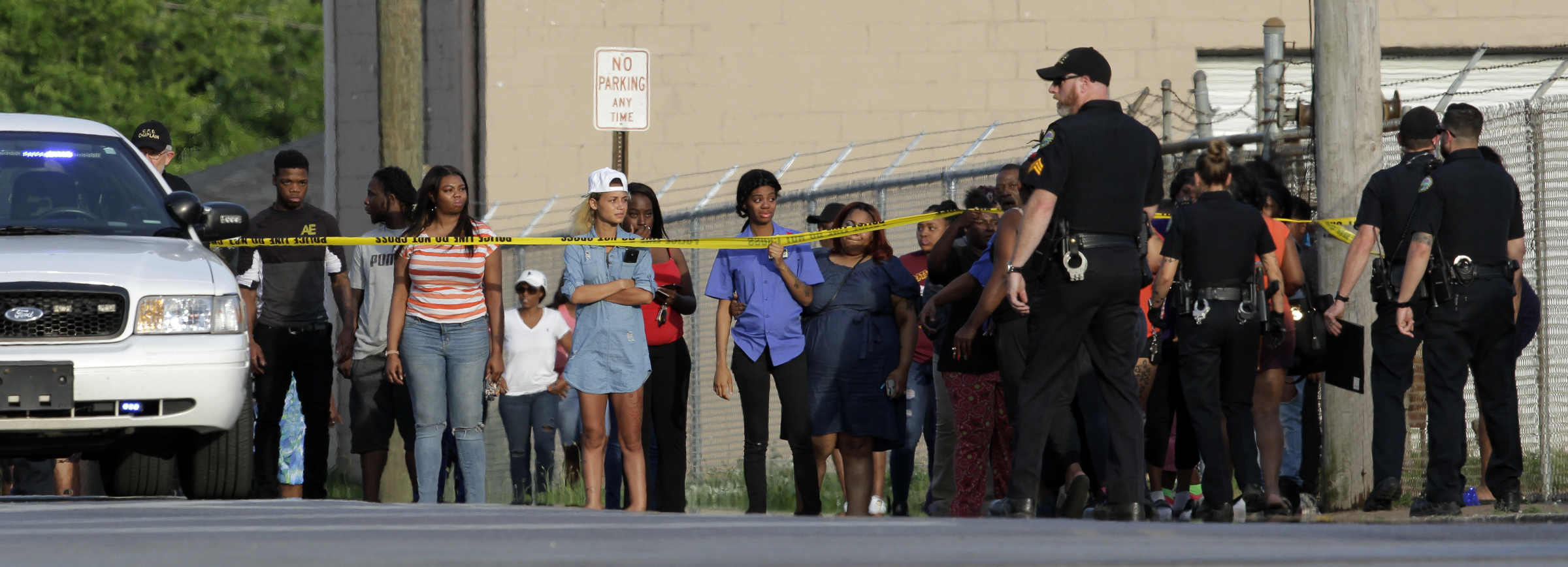 People look on as a woman is moved back behind the crime scene tape as officers work the scene of a fatal shooting at the intersection of Central Avenue and West 38th Street on Sunday, May 6, 2018 in Chattanooga, Tenn.