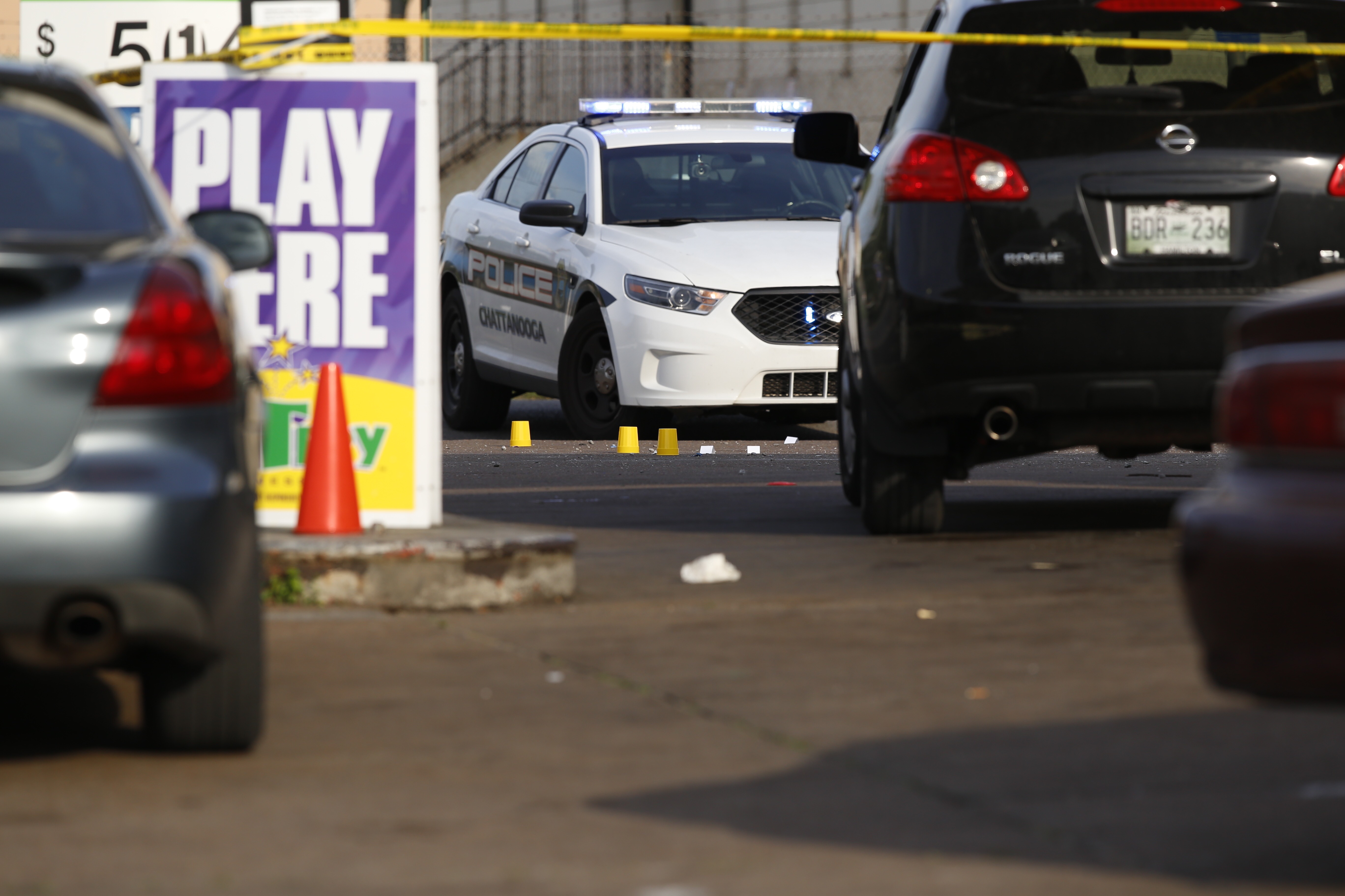 Evidence markers are seen on the ground in front of the Nine Brothers convenience store along West 38th Street in Chattanooga.