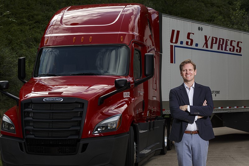 In this Aug. 23, 2017, staff file photo, U.S. Xpress CEO Eric Fuller stands next to a vehicle at the company's headquarters in Chattanooga, Tenn.