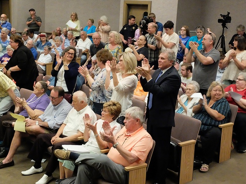 East Ridge residents stand and applaud the vote at Monday morning's special City Council meeting where the council voted to abolish the development plan instituted by Mayor Brent Lambert.