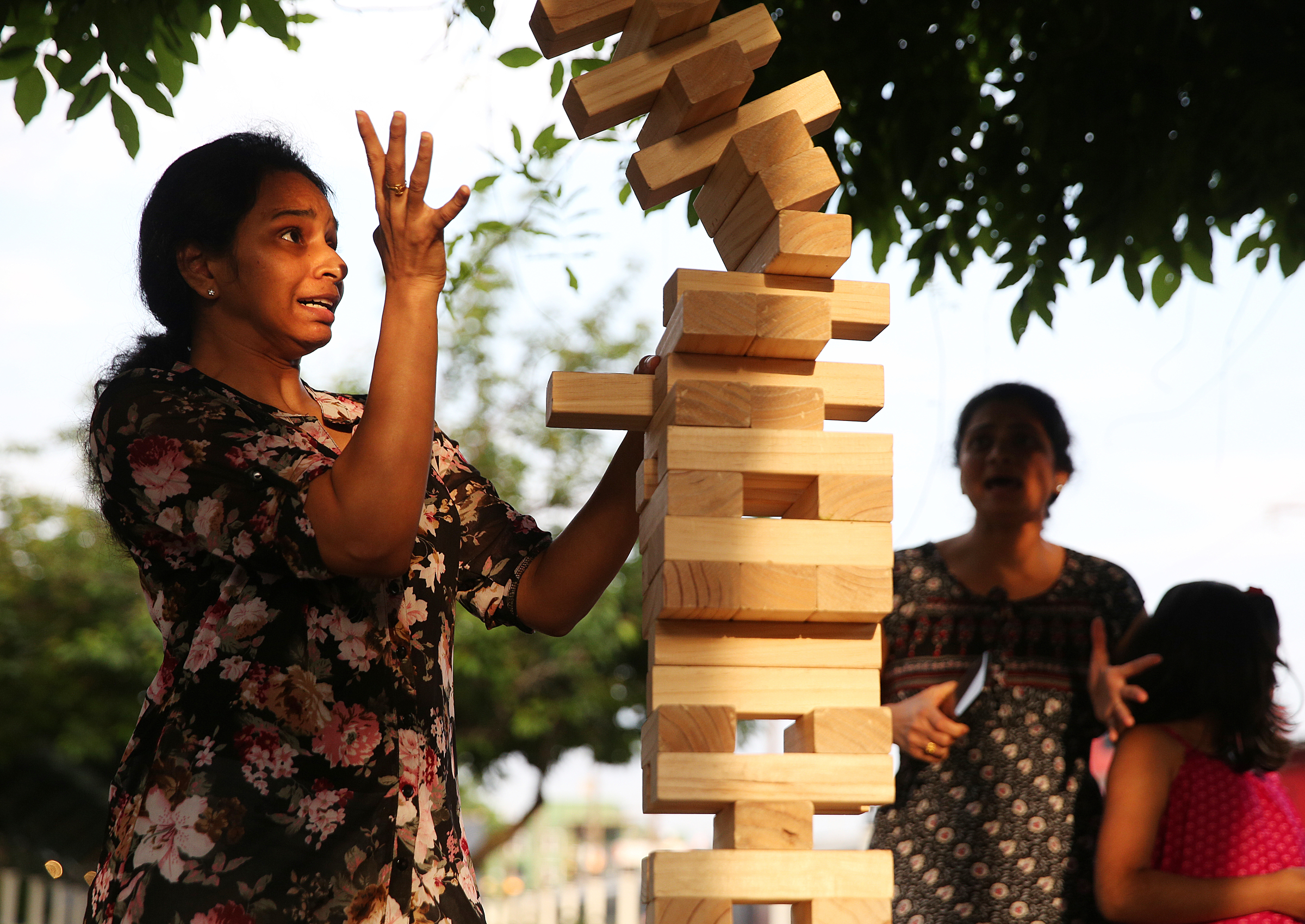 Pratuysha Uddaraju reaches up as the Jenga Giant pile falls as she plays with others Friday, May 4, 2018 at the Chattanooga Choo Choo in Chattanooga, Tenn. Uddaraju and others she was visiting with spotted the Jenga blocks as they were walking through the area and decided to stop and play. Though Uddaraju was using all of her concentration to pull out the block, there just was enough left to keep the structure stable.