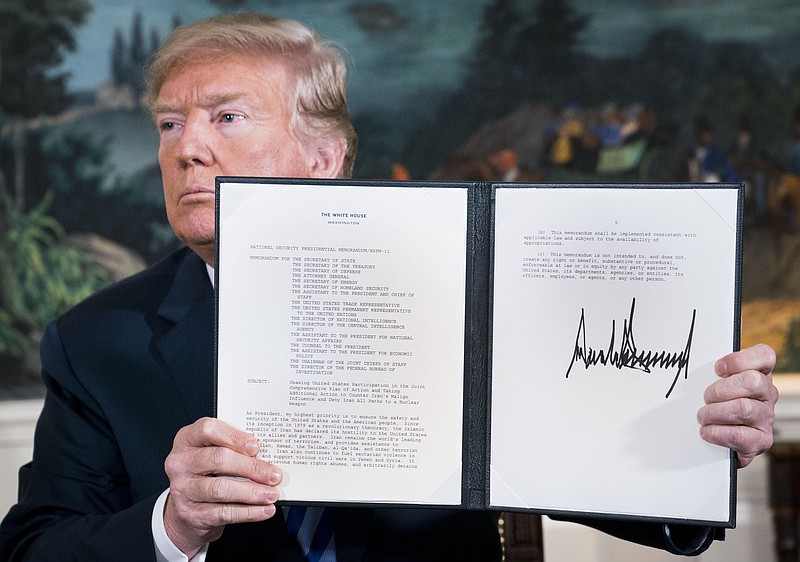 President Donald Trump signs a presidential memorandum pulling out of the Iran nuclear deal in the Diplomatic Room of the White House in Washington, May 8, 2018. Trump declared on Tuesday that he was pulling out of the Iran nuclear deal, unraveling the signature foreign policy achievement of his predecessor, Barack Obama, and isolating the United States among its Western allies. (Doug Mills/The New York Times)
