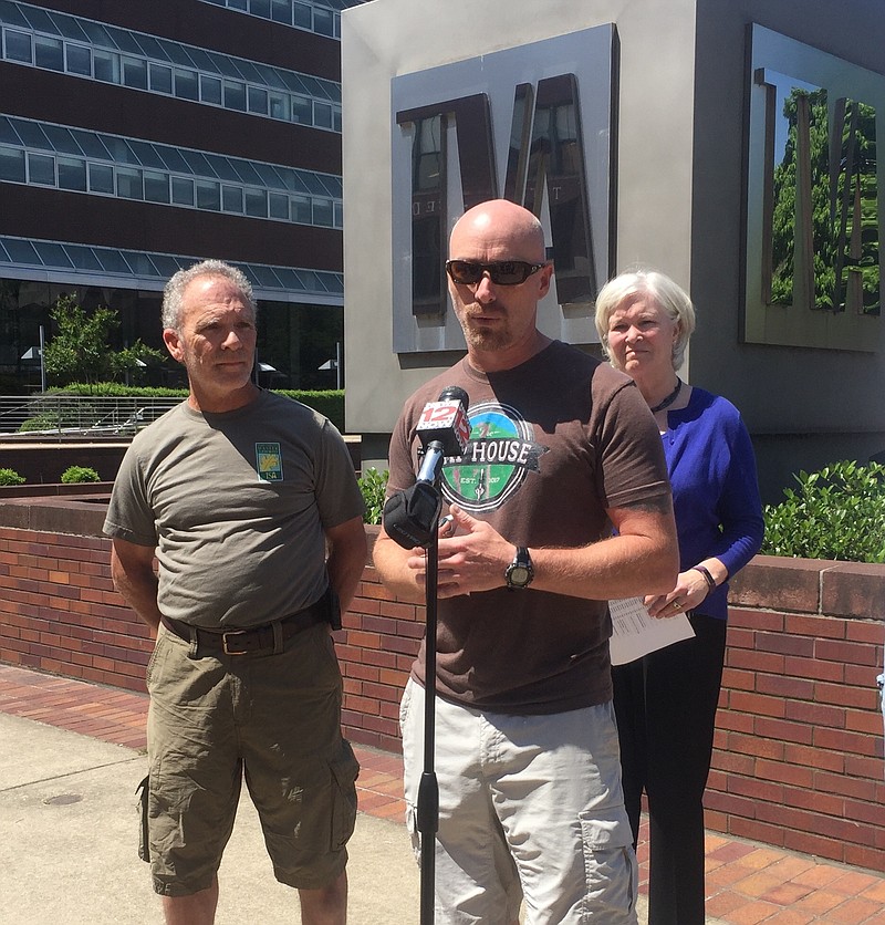 Chris Calhoun, owner of The Tap House and The Brew Market, talks against a proposed grid access fee in front of TVA's power headquarters in Chattanooga along with Jon Nessle, left, the arborist and landscape coach, and Lenda Sherrell, right, the state director for the Tennessee Small Business Alliance