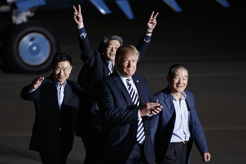 The three American prisoners freed from North Korea, Tony Kim, left, Kim Hak-song and Kim Dong-chul, raise their hands in jubilation as they are welcomed to Joint Base Andrews, Md., by President Donald Trump early Thursday morning. The return of the prisoners to the U.S. removed a delicate obstacle as Trump prepares to sit down with North Korea's leader, Kim Jong Un, for a landmark nuclear summit meeting. (Tom Brenner/The New York Times)