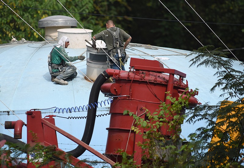 Two men work to put a new vent cap on a 250,000-gallon water holding tank for Town of Signal Mountain Public Utility in October 2017. The town is considering the sale of its water system and is holding a public input meeting on the topic Thursday, May 17 at 6:30 p.m. (Staff file photo by Tim Barber)