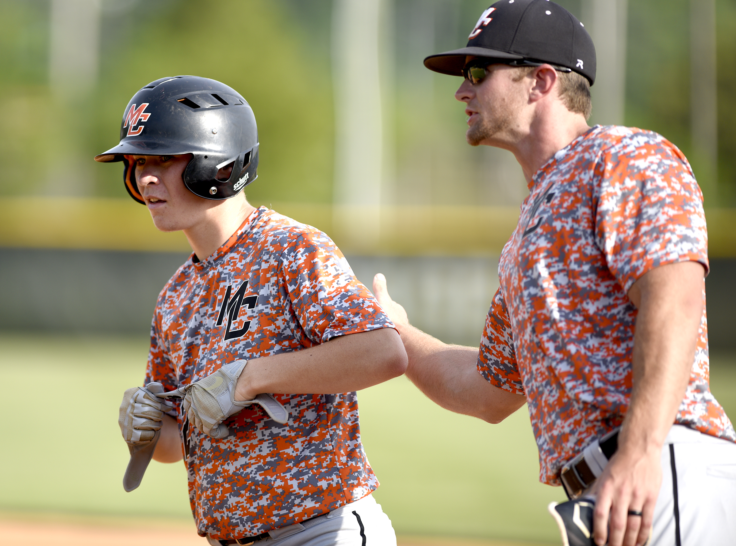 Meigs County DH, Alexander Herd (12) is congratulated by the first base coach after a 2-run single. The Meigs County Tigers visited the Hixson Wildcats in the TSSAA Region 3-AA baseball final on May 14, 2018.