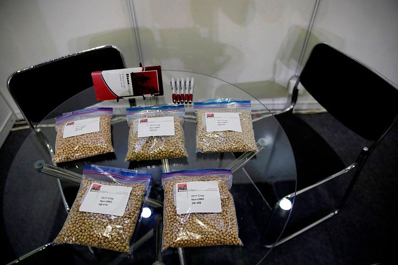 FILE - In this April 12, 2018 file photo, packets of raw soybeans are placed on a table at a U.S. soybean company's booth at the international soybean exhibition in Shanghai, China. With the threat of tariffs and counter-tariffs between Washington and Beijing looming, Chinese buyers are canceling orders for U.S. soybeans, a trend that could deal a blow to American farmers if it continues. At the same time, farmers in China are being encouraged to plant more soy, apparently to help make up for any shortfall from the United States. (AP Photo/Andy Wong, File)