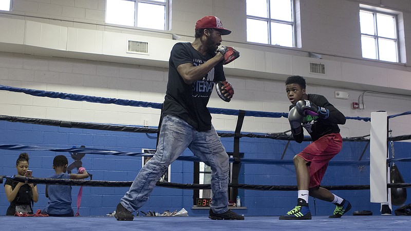 Mike Dawson, center, trains in the ring with his 16-year-old son Mike Dawson Jr. at the Westside boxing gym on Monday, May 14, 2018 in Chattanooga, Tenn.