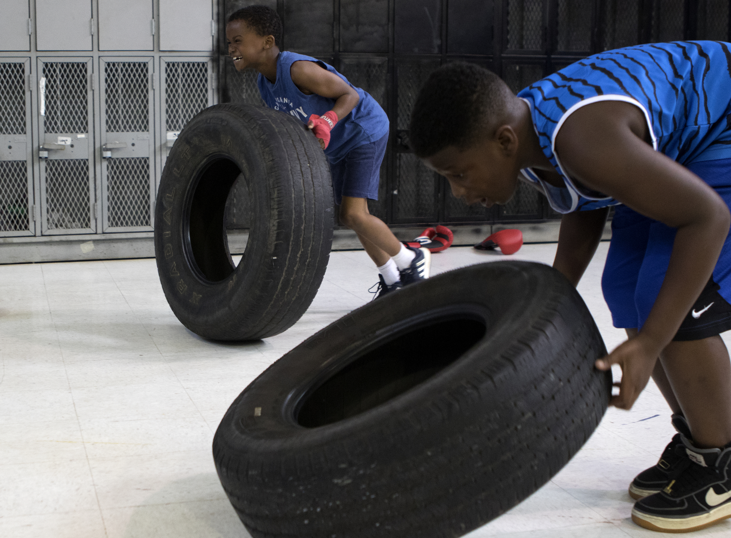 Eight-year-olds Jaden Medley, back, and Drelyn Parks flip tires before practicing at the Westside boxing gym on Monday, May 14, 2018 in Chattanooga, Tenn.