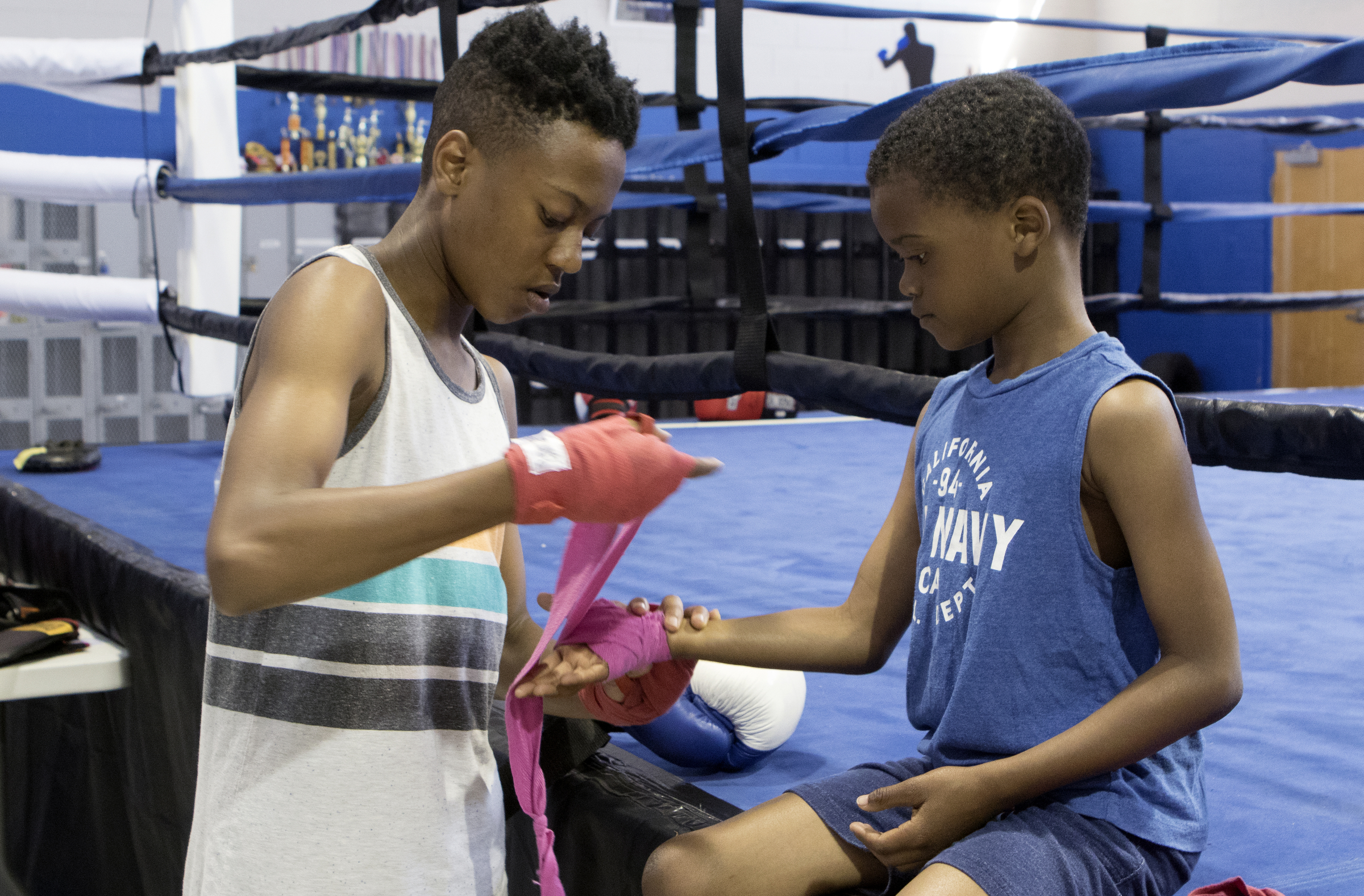 Twelve-year-old Zion Clark, left, helps 8-year-old Jaden Medley tape up his hands before training at the Westside boxing gym on Monday, May 14, 2018 in Chattanooga, Tenn.