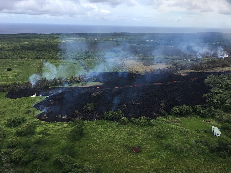 In this May 13, 2018, photo released by the U.S. Geological Survey, gases rise from a fissure near Pahoa, Hawaii. The new fissure in Hawaii's Puna District sent gases and lava exploding into the air, spurring officials to call for more evacuations as residents waited for a possible major eruption at Kilauea volcano's summit. (U.S. Geological Survey via AP)