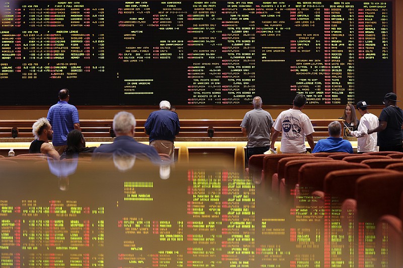 People line up to place bets in the sports book at the South Point hotel-casino, Monday, May 14, 2018, in Las Vegas. The Supreme Court on Monday gave its go-ahead for states to allow gambling on sports across the nation, striking down a federal law that barred betting on football, basketball, baseball and other sports in most states. (AP Photo/John Locher)