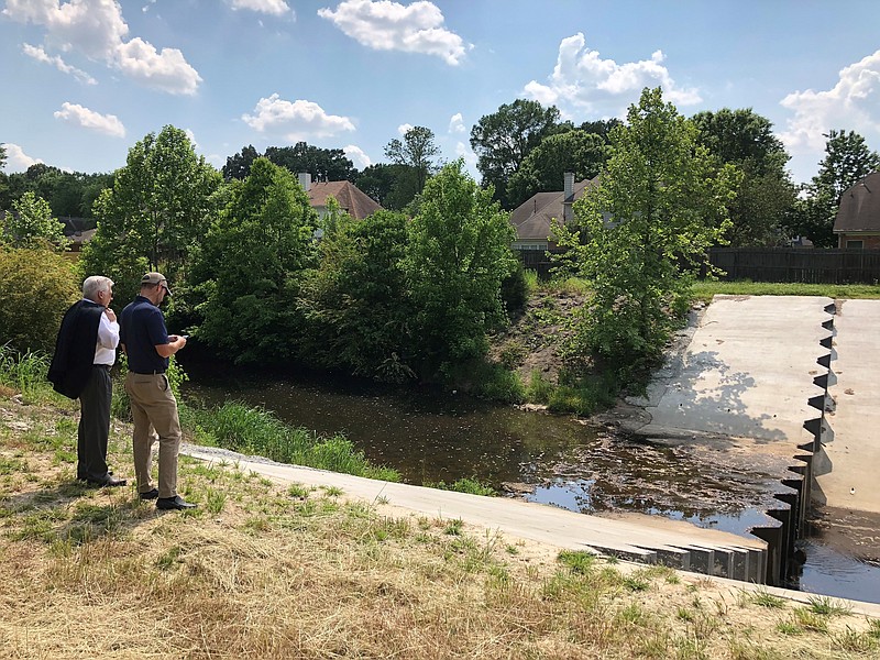 Two men inspect a U.S. Army Corps of Engineers project to prevent erosion in an important storm sewage channel in a Tennessee suburb, Tuesday, May 15, 2018, in Germantown, Tenn. (AP Photo/Adrian Sainz)