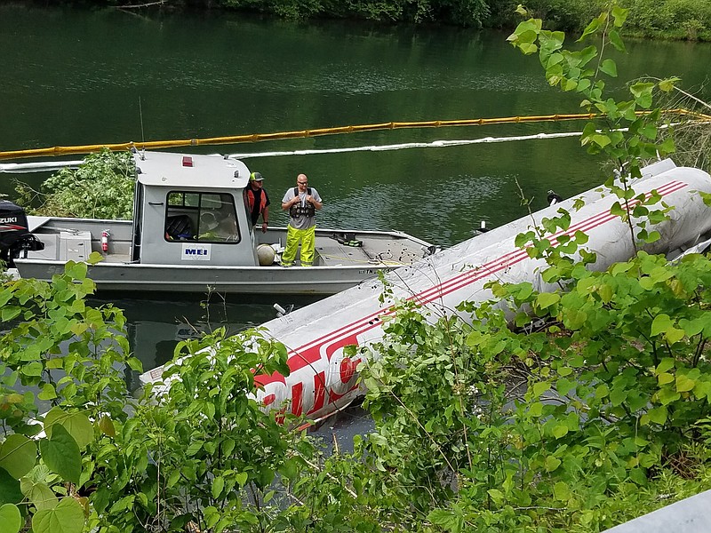 Divers are in the Ocoee River at the site of a diesel and gasoline spill after an 8,000-gallon tanker truck overturned into the water Tuesday evening on U.S. Highway 64.