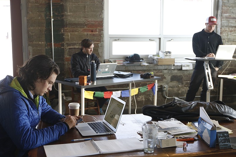 RootsRated CEO Fynn Glover, director of digital marketing Bryson Moore, and former creative director Jake Wheeler, from left, work in their former Chattanooga office in 2015.