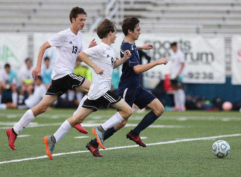 Chattanooga School for the Arts and Sciences' Nicholas Webber (10) pushes the ball downfield while being chased by Signal Mountain's Leon Menge (13) and Tanner Ward (8) during the CSAS vs. Signal Mountain Region 3-A soccer game Thursday, May 17, 2018 at Boyd-Buchanan School in Chattanooga, Tenn.