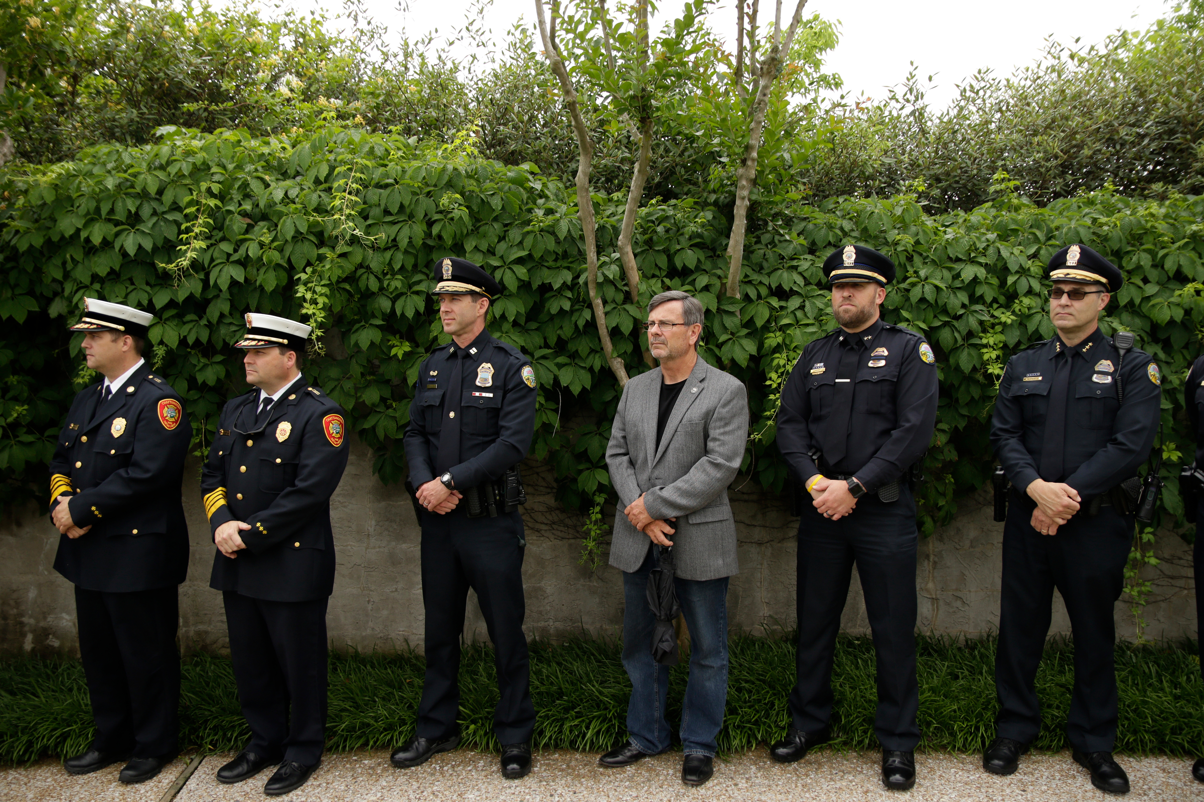 Chattanooga police and firefighters listen to a speaker in the Bluff View Sculpture Garden during the Veterans Bridge Flag Raising Ceremony on Friday, May 18, 2018, in Chattanooga, Tenn. The annual installation of new American flags on the bridge ahead of Armed Forces Day honors the city's veterans.