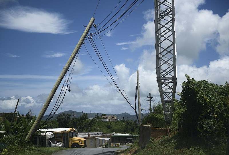 In this May 16, 2018 photo, an electric power pole leans over the road in the Piedra Blanca area of Yabucoa, Puerto Rico. Most of those still without power live in this town, which was the first place in Puerto Rico struck by Hurricane Maria on Sept. 20. (AP Photo/Carlos Giusti)