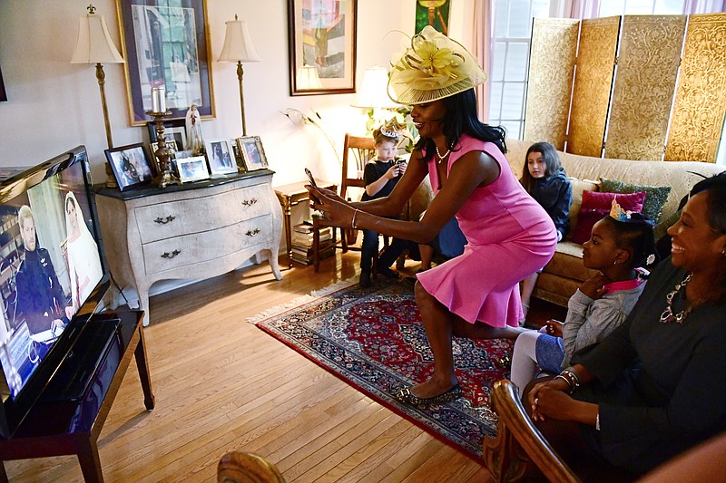 
              Jenice Armstrong of Burlington, N.J. takes a photo during a television viewing party of the royal wedding of Meghan Markle and Prince Harry , Saturday, May 18, 2018, at the Armstrong-Turner residence in Burlington, N.J.  From pubgoers in pajamas to merrymakers in finery at a posh hotel, Americans cheered and teared up Saturday as they watched Meghan Markle marry Prince Harry in a royal wedding with trans-Atlantic resonance. (AP Photo/Corey Perrine)
            