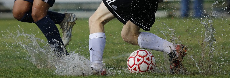 Water splashes up as Signal Mountain's Aaron Easterly (white socks) plays the ball at Signal Mountain Middle/High School on Sunday, May 20, 2018 in Signal Mountain, Tenn.