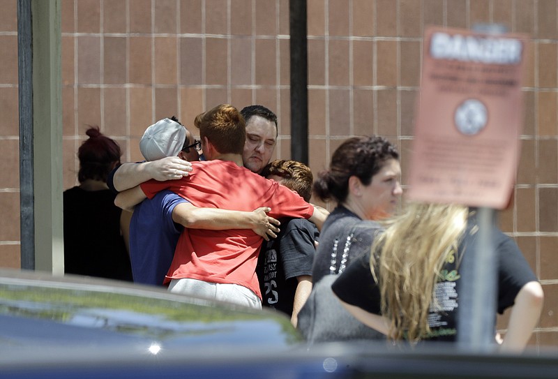 People react outside the unification center at the Alamo Gym, following a shooting at Santa Fe High School Friday, May 18, 2018, in Santa Fe, Texas. (AP Photo/David J. Phillip)

