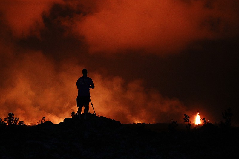 Peter Vance, 24, photographs lava erupting in the Leilani Estates subdivision near Pahoa, Hawaii Friday, May 18, 2018.