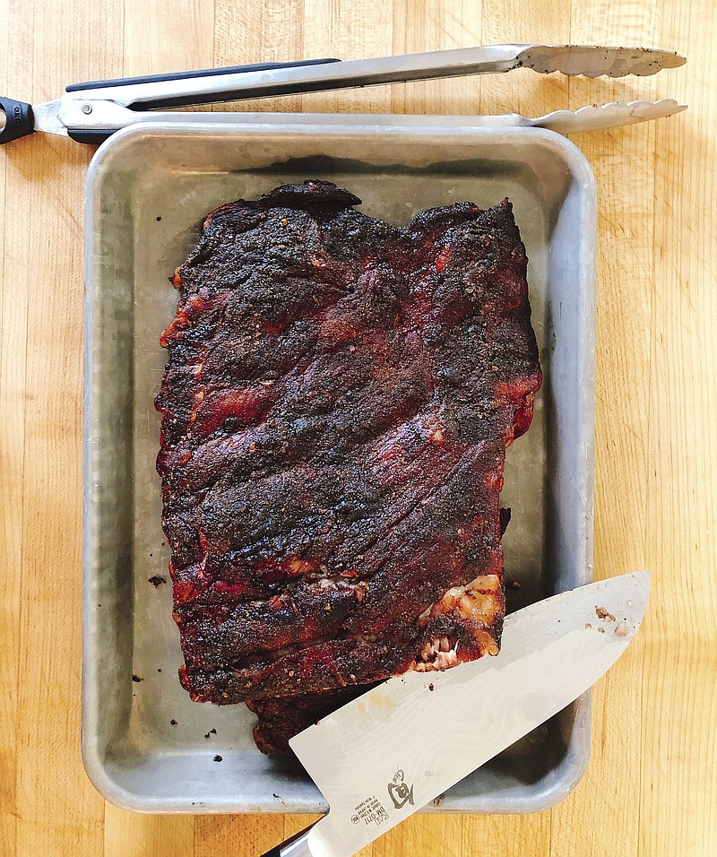 This May 10, 2018 photo shows barbecue pork ribs in Amagansett, N.Y. This dish is from a recipe by Elizabeth Karmel. (Elizabeth Karmel via AP)