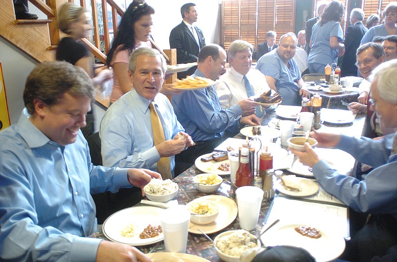 Former President George W. Bush tries the ribs at Porkers Bar-B-Que during an unexpected stop at the restaurant on Market Street in 2007. The president was in town to talk about healthcare issues, and made stops at Erlanger and the Chattanooga Convention Center.