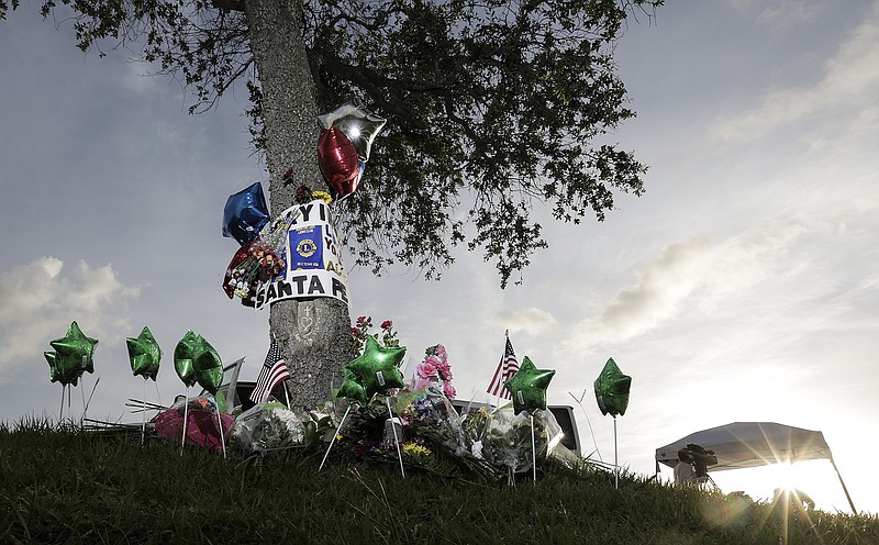 Television newscasters prepare to give updates near a memorial in front of Santa Fe High School on Sunday, May 20, 2018 in Santa Fe, Texas, where a student shot and killed eight classmates and two teachers at Santa Fe High School. (Elizabeth Conley/Houston Chronicle via AP)