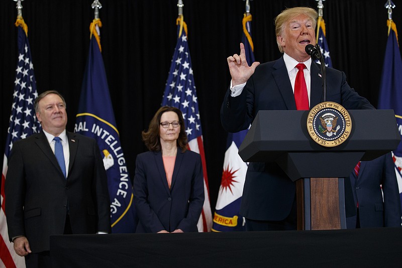 Secretary of State Mike Pompeo, left, and incoming Central Intelligence Agency director Gina Haspel, center, listen to President Donald Trump speak during a swearing-in ceremony at CIA Headquarters, Monday, May 21, 2018, in Langley, Va. (AP Photo/Evan Vucci)