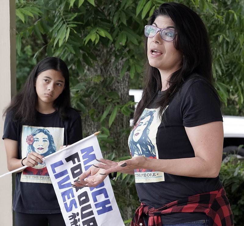 Christina Delgado, right, talks about the school shooting as her daughter, London, listens Sunday, May 20, 2018, in Santa Fe, Texas. Delgado watched in horror last week as the extreme gun violence she had marched to prevent arrived in her town. A gunman opened fire inside Santa Fe High School on Friday, killing 10 people. (AP Photo/David J. Phillip)
