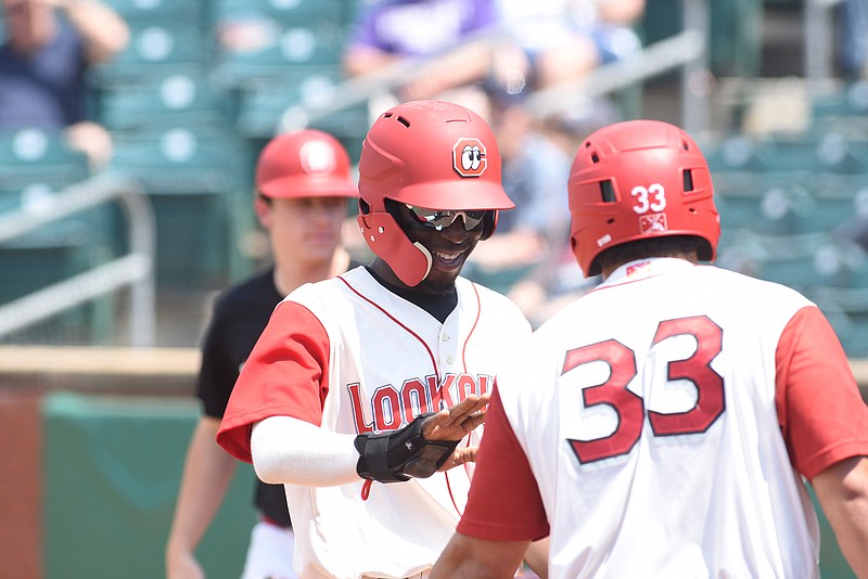 Nick Gordon gets congratulation from T.J. White (33) after scoring in the third inning against the Tennessee Smokies Sunday afternoon at AT&T Field.