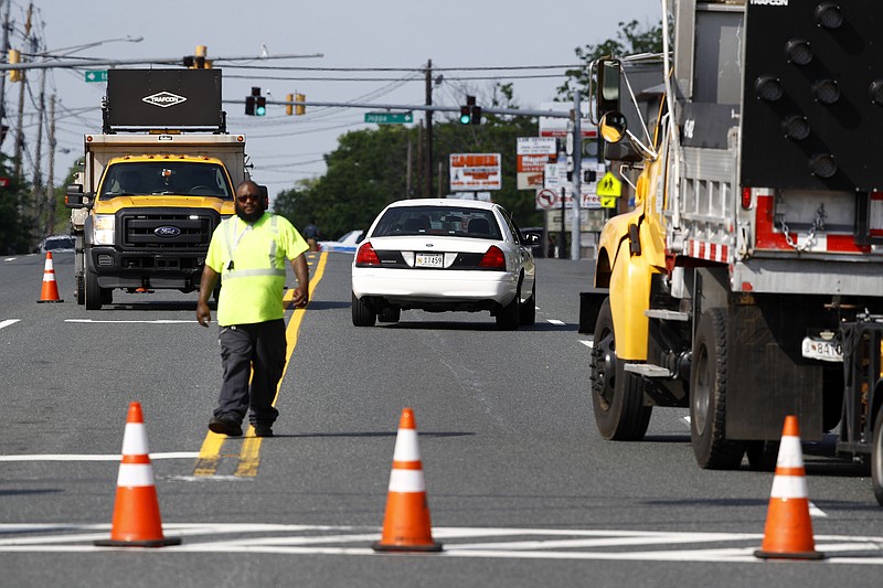 An emergency vehicle passes a roadblock near a scene where a Baltimore County police officer died, while investigating a suspicious vehicle, Monday, May 21, 2018, in Perry Hall, Md. Heavily armed police swarmed into the leafy suburb, searching for at least one armed suspect. (AP Photo/Patrick Semansky)