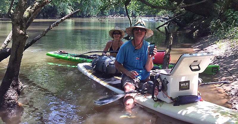 Kris and Randy Whorton break for snacks along a shady stretch of the French Broad River.