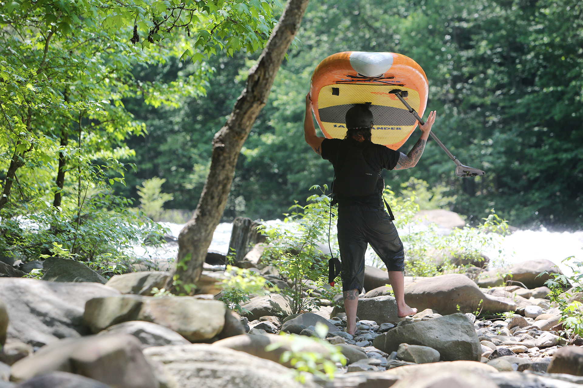 Alex Storgion, 26, walks around a portion of rapids with his standup paddle board on the Ocoee River in Benton, Tenn., Monday, May 14, 2018.