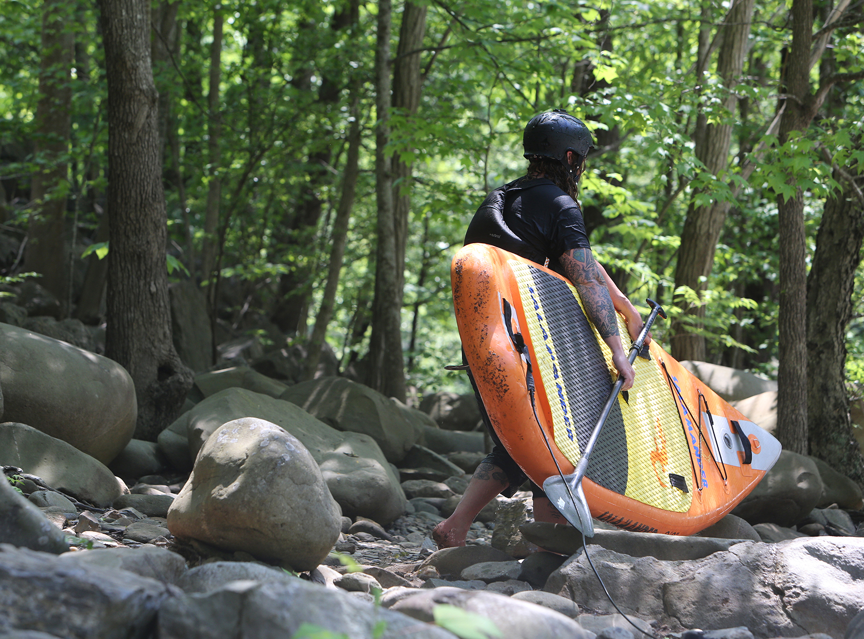 Alex Storgion, 26, walks around a portion of rapids with his standup paddle board on the Ocoee River in Benton, Tenn., Monday, May 14, 2018.