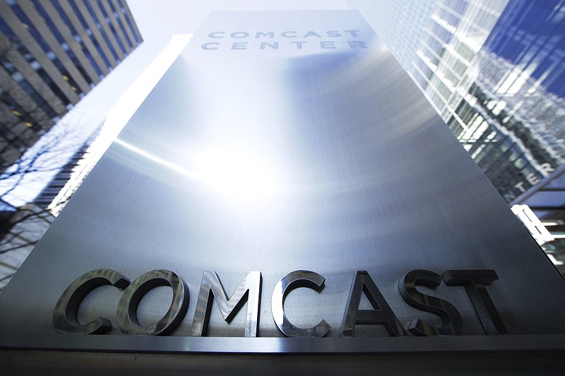 FILE - This March 29, 2017, file photo shows a sign outside the Comcast Center in Philadelphia. Comcast says it’s considering making an offer to buy Twenty-First Century Fox, which would put it in a head-to-head bidding fight with Disney. (AP Photo/Matt Rourke, File)