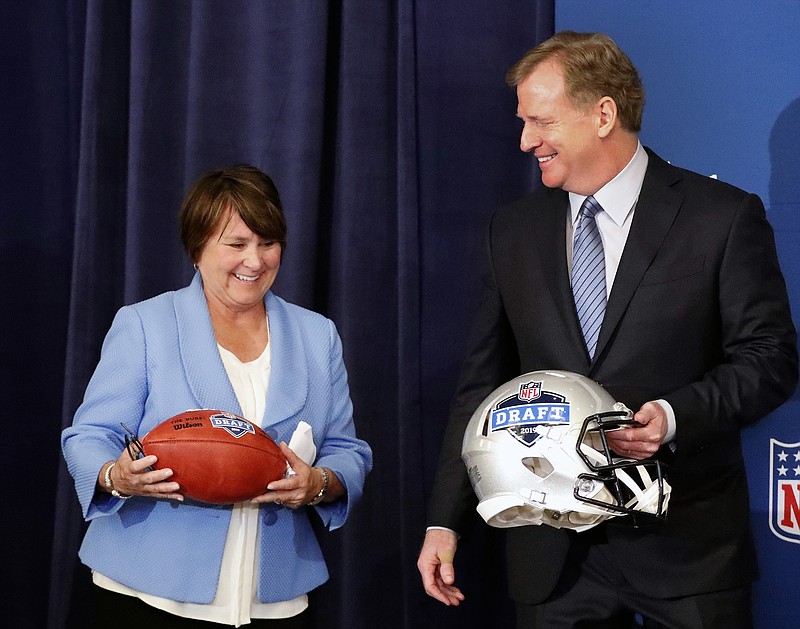 Tennessee Titans owner Amy Adams Strunk holds a football as she and NFL commissioner Roger Goodall prepare for a photo after it was announced that Nashville will host the 2019 NFL draft during the NFL owner's spring meeting Wednesday, May 23, 2018, in Atlanta. (AP Photo/John Bazemore)

