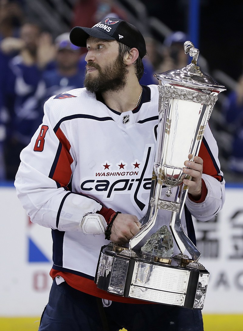 
              Washington Capitals left wing Alex Ovechkin (8) holds the Prince of Wales trophy after the Capitals defeated the Tampa Bay Lightning 4-0 during Game 7 of the NHL Eastern Conference finals hockey playoff series Wednesday, May 23, 2018, in Tampa, Fla. (AP Photo/Chris O'Meara)
            