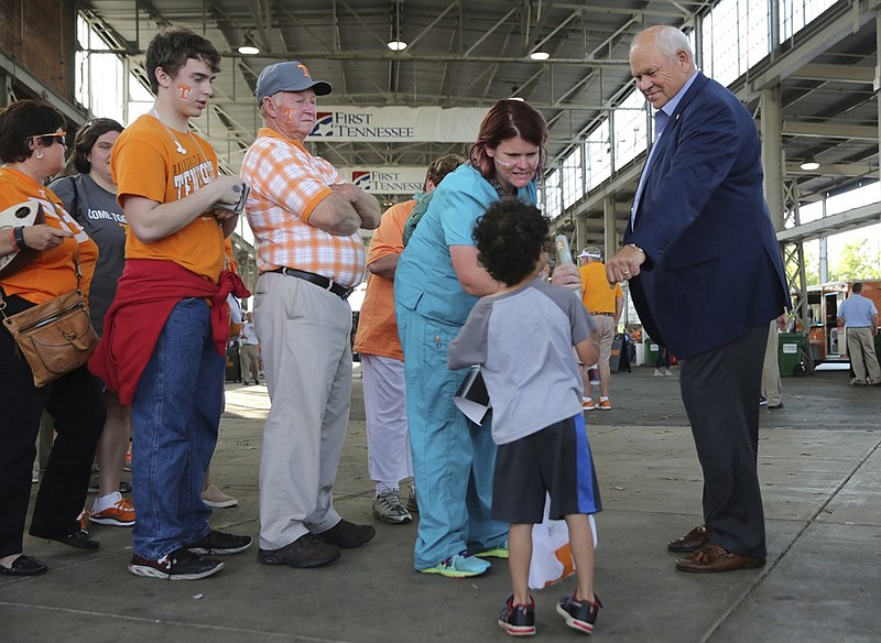 Tennessee athletic director Phillip Fulmer offers a fist bump to Lennox Sam, 4, during the Big Orange Caravan stop this month at the First Tennessee Pavilion. Fulmer touted the department's academic success this week after Tennessee student-athletes' combined 3.07 GPA for spring semester tied the school record. (Staff File Photo by Erin O. Smith/Times Free Press)