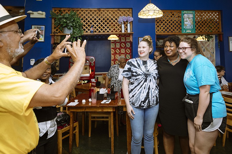 FILE — Georgia gubernatorial Democratic nominee Stacey Abrams poses for a photo with the staff at Schroeder's New Deli in Rome, Ga., in mid-May. Last week, Abrams became the first black woman to win a major political party's nomination for governor. (Audra Melton/The New York Times)