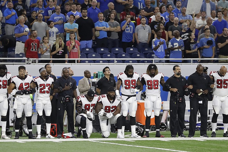 Atlanta Falcons defensive tackles Grady Jarrett (97) and Dontari Poe (92) take a knee during the national anthem before an NFL football game in 2017 in Detroit.
