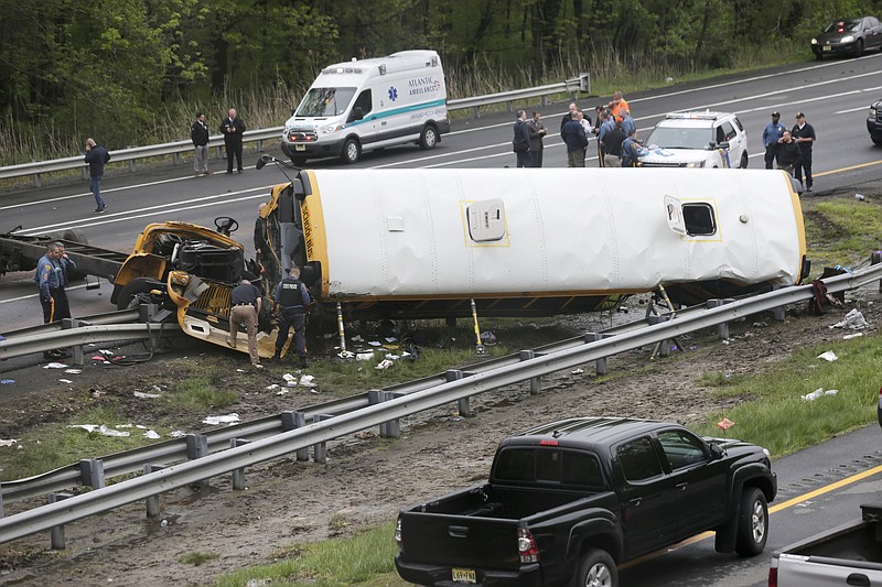 In this May 17, 2018, file photo, emergency personnel work at the scene of a school bus and dump truck collision on Interstate 80 in Mount Olive, N.J. Hudy Muldrow Sr., the school bus driver caused the fatal crash by crossing three lanes of traffic in an apparent attempt to make an illegal U-turn, according to a criminal complaint released Thursday, May 24, that charged him with vehicular homicide. (AP Photo/Seth Wenig, File)