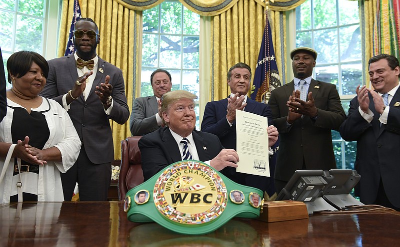 President Donald Trump center, posthumous pardons Jack Johnson, boxing's first black heavyweight champion, during an event in the Oval Office of the White House in Washington, Thursday, May 24, 2018.