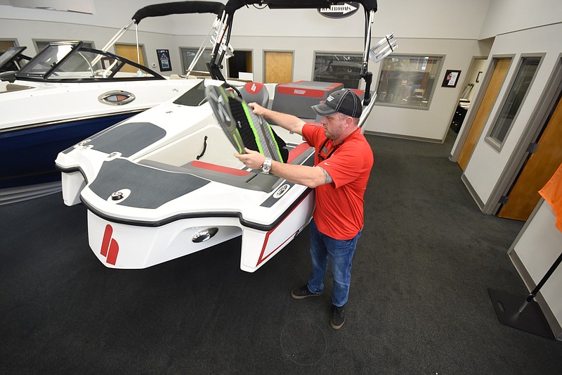 Michael Porter, sales representative at Erwin Marine Sales, stands in the showroom with a Heyday Wake Surf boat.