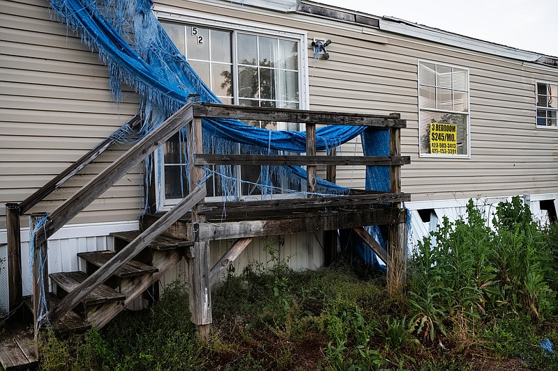 A sign indicates a monthly rental fee in the window of a damaged trailer in the Stoney Pointe Mobile Home Park on Thursday, May 10, 2018, in Rossville, Ga. 